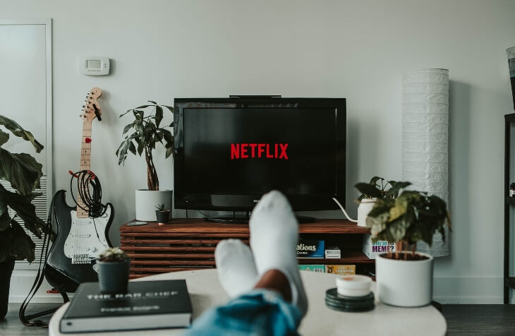 Netflix logo na televizoru čovek koji gleda