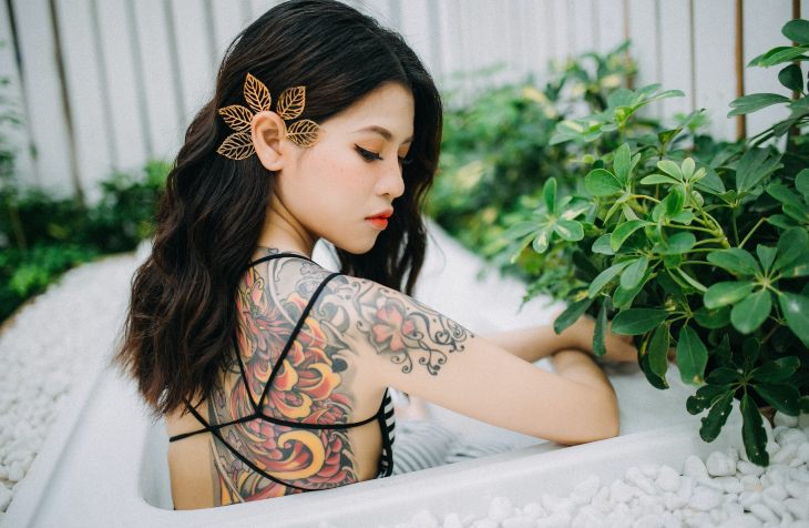 Devojlka sa tetovažama na leđima