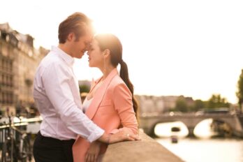 Muškarac i žena zagrljeni stoje jedno uz drugo u gradu