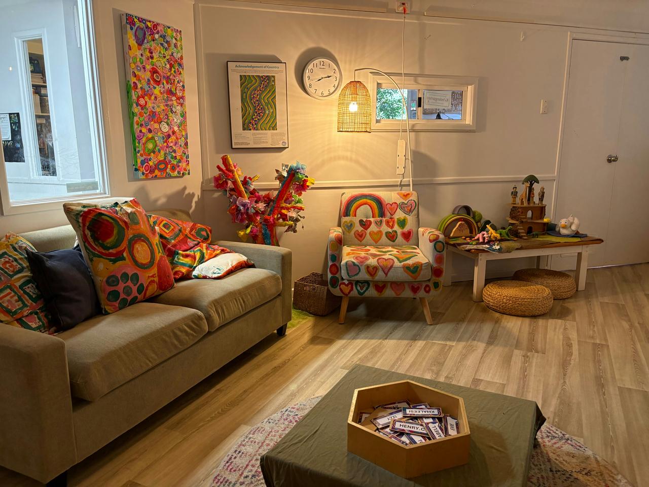 Vesela dnevna soba sa šarenim ukrasima i prirodnim svetlom.