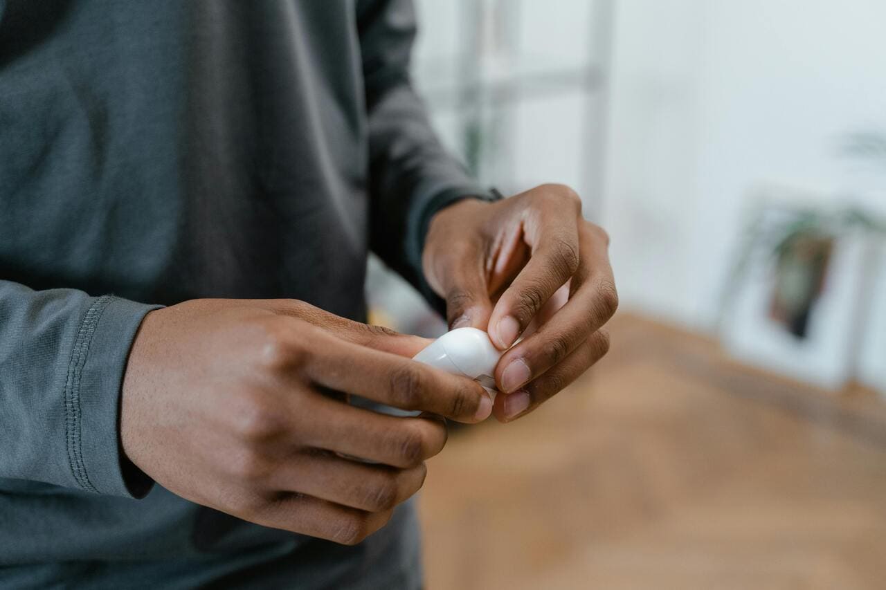 Ruke drže belu bežičnu slušalicu