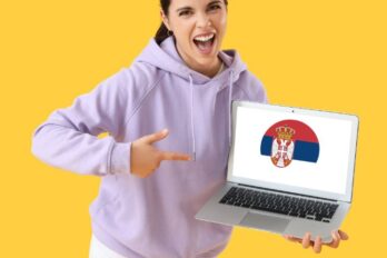 Žena drži laptop sa zastavom Srbije