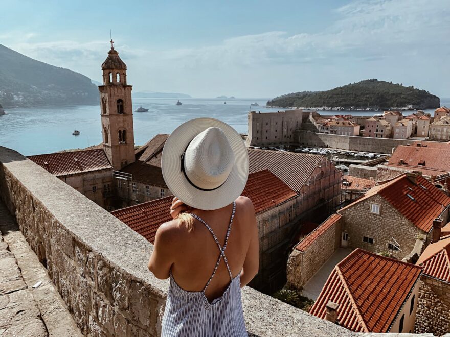 Žena gleda na more sa tvrđave u starom morskom gradu