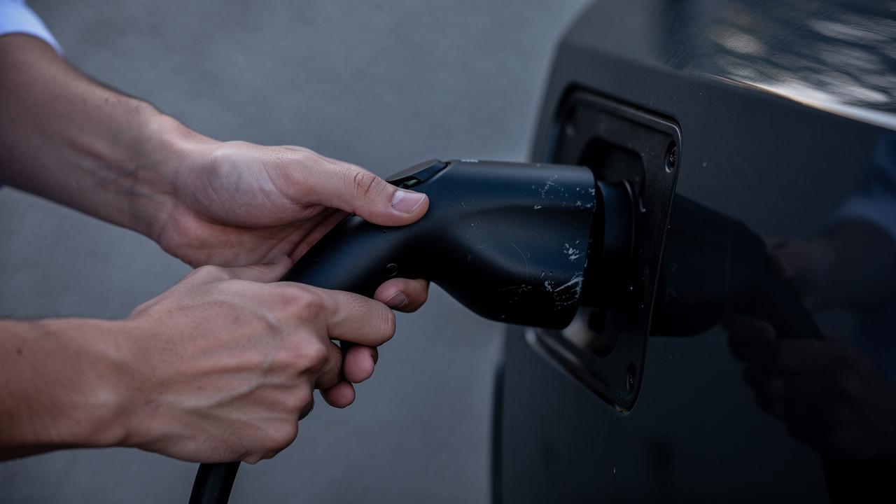 Ruke uklapaju punjač u priključak električnog automobila